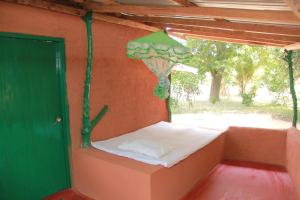 a small bed in a room with a green door at Yala Wild House in Yala