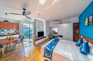 Un dormitorio con una cama tamaño king y un comedor. en Cani Beach House, en Da Nang