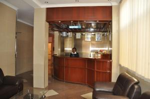 a woman standing at a counter in a lobby at Rich Hotel in Arusha