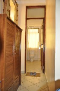 a bathroom with a toilet and a pair of shoes on the floor at Rich Hotel in Arusha
