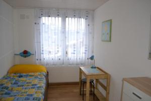a bedroom with a bed and a table and a window at Elfe-Apartments Apartment for 6 guests with patio in Emmetten