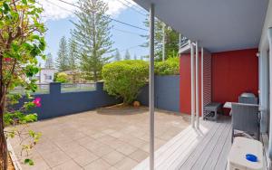 
a patio area with a walkway and patio furniture at Adrift Apartments in Yamba
