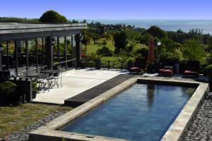 a swimming pool in a backyard with a gazebo at Domaine de La Paix in Rodrigues Island