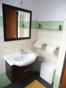 ein Bad mit einem Waschbecken und einem Spiegel in der Unterkunft BB Le Violette in Tortolì