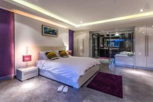 a bedroom with a large bed and a purple wall at Dasiri Beach Apartment Wongamat in Pattaya North +19 photos