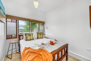 a bedroom with a bed with white sheets and a window at Cottonwood Cottage - Couples 'pet friendly' retro escape in Mudjimba