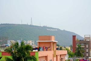 Vue sur une ville avec une montagne en arrière-plan dans l'établissement Blue stone homestay guesthouse, à Visakhapatnam