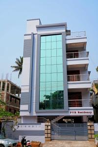 a tall white building with a large window at Blue stone homestay guesthouse in Visakhapatnam