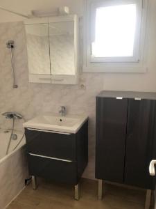 ein Badezimmer mit Waschbecken und Badewanne in der Unterkunft Kennedy in Saint-Jean-de-Braye + 22 Fotos