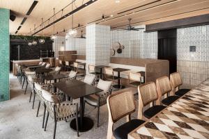 a restaurant with tables and chairs in a room at Nest Hotel Naha Nishi in Naha