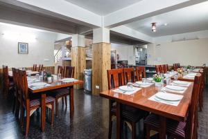 a dining room with a large wooden table and chairs at Hotel Pride in Kalimpong