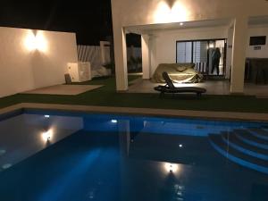 een slaapkamer en een zwembad 's nachts met een bed bij House In Miramar Seaview And Private Pool templada in Guaymas