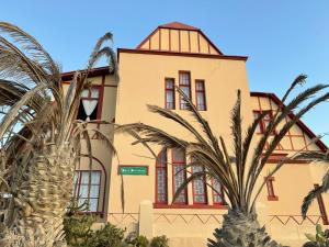 ein Gebäude mit Palmen davor in der Unterkunft Haus Panorama-3 bedrooms with great views in Lüderitz