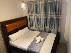1 dormitorio con 1 cama con 2 toallas en Andyhill Studio Apartment -Tsavo Embakasi Near Sgr, en Nairobi