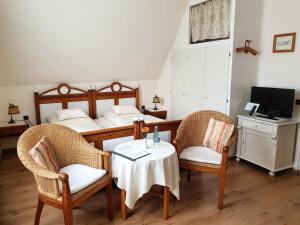 1 Schlafzimmer mit 2 Betten, einem Tisch und Stühlen in der Unterkunft Pension Jepsen in Glücksburg