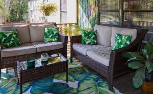 a porch with wicker chairs and a couch and a table at Pleasant Days Lodging Tropical Master Suite in Homosassa +12 photos