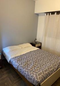 1 dormitorio con cama y ventana en Salta & Luro en Mar del Plata