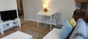 sala de estar con mesa y sofá en Apartament Jasińskiego z ogrodem, en Piaseczno