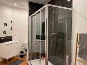 ein Badezimmer mit einer Dusche und einem Glasgehege in der Unterkunft le tricosy jacuzzi et sauna privatif in Tricot