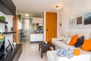 a living room with a white couch and a kitchen at Angy Apartment in Alcudia