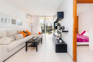 a white living room with a couch and a table at Angy Apartment in Alcudia