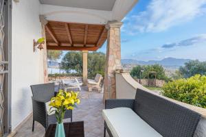 um pátio com uma mesa e cadeiras e um vaso de flores em Bella Vista With Sea View - Happy Rentals em Cugnana