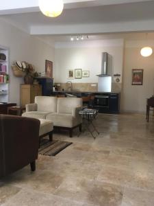 a living room with a couch and a kitchen at Coeur de l'Arquet in LʼIsle-sur-la-Sorgue