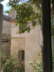 a view of a building from a window at Coeur de l'Arquet in LʼIsle-sur-la-Sorgue