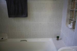 a white bathroom with a tub and a sink at Casa en Gregg -Exquisite 2-bedroom spacious condo in East London