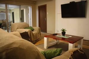 a living room with a coffee table and a tv at Casa en Gregg -Exquisite 2-bedroom self catering unit - 1 car parking space in East London