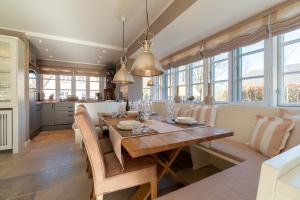 a kitchen and dining room with a wooden table and chairs at Chelseas Hüs in Borgsum