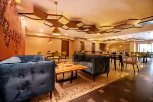 a restaurant with couches and tables and a dining room at Hotel One Tower Gulberg, Lahore in Lahore