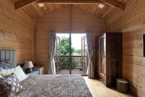 a bedroom in a log cabin with a bed and a balcony at The Pine Loft in Bangalore