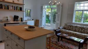 een woonkamer met een bank en een tafel bij Willow Cottage in Kaapstad