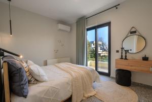 een slaapkamer met een bed met een spiegel en een raam bij Niriides in Preveza