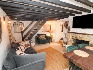 a living room with a couch and a fireplace at Hobbes Cottage in Malmesbury