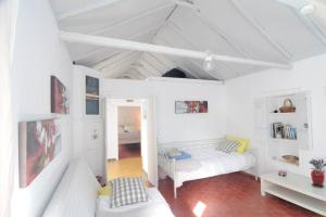 Habitación blanca con cama y sofá en LOVELY QUIET HOUSE WITH GARDEN en Spétses