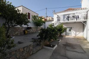 a courtyard of a building with trees on a balcony at LOVELY QUIET HOUSE WITH GARDEN in Spetses