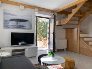 a living room with a large television and a couch at Inevig Holiday home in Rogoznica