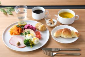 - une table avec deux assiettes de nourriture et une tasse de café dans l'établissement MIROKU NARA by THE SHARE HOTELS, à Nara