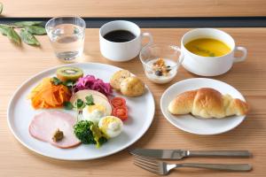 a table with two plates of food and a cup of coffee at MIROKU NARA by THE SHARE HOTELS in Nara