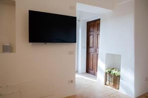 a living room with a flat screen tv on a wall at Dammuso Oltremare - Appartamento Lantana in Pantelleria