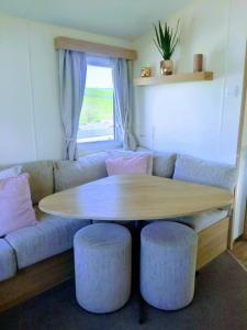 a living room with a table and a couch at 4 Berth Couples and Family Caravan in Beautiful Newquay Bay Resort in Newquay