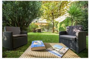 two chairs and a coffee table in a yard at Hotel San Carlo in Marina di Pietrasanta