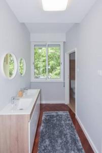 a white bathroom with a sink and a window at Lolla's City House in Porto