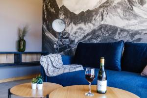 a blue couch with a glass of wine on a table at 285 Apartments in Czarny Dunajec