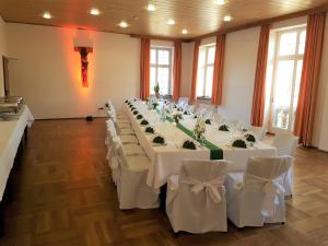 a banquet hall with white tables and white chairs at Kloster Langwaden in Grevenbroich