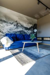 Una sala de estar con un sofá azul y una mesa. en 285 Apartments, en Czarny Dunajec