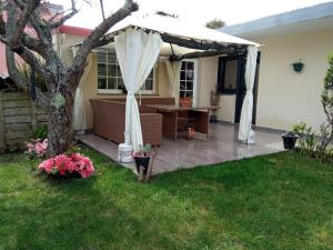 オ・グローベにあるJARDIN, TERRAZA Y BARBACOAの白い天蓋とテーブル付きの裏庭のパティオ