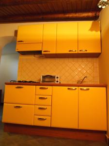 a kitchen with yellow cabinets and a sink at Alberico Gentili in Palermo